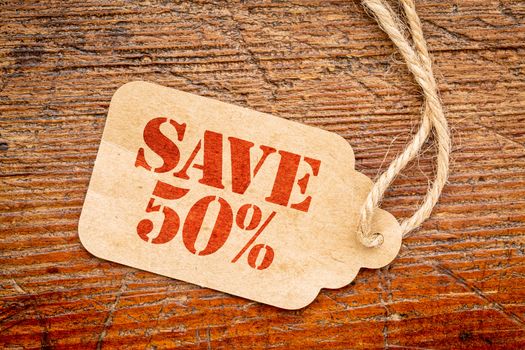 save 50 percent  sign a paper price tag against rustic red painted barn wood - shopping concept