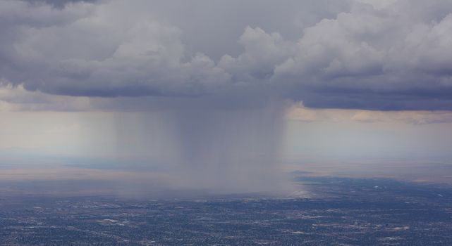 Rain pours onto Albuquerque Airport from clouds over the city.  View as seen from Sandia Crest Highway on scenic byway to peak.  