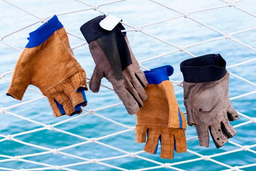 Sailing glove hanging on the nets  of sailing yacht.