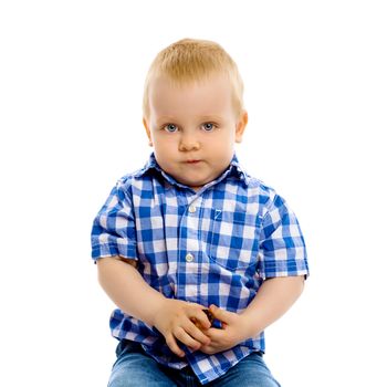 A little boy in a plaid shirt and jeans