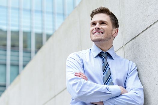 Image of a corporate executive standing against wall