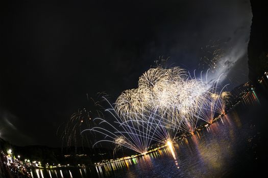 Fireworks on the Lugano Lake in a summer evening seen from lakefornt of Lavena-Ponte Tresa, Lombardy - Italy