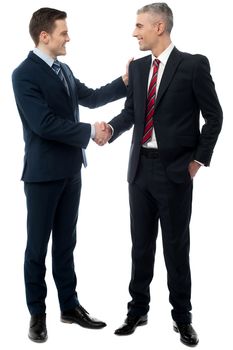 Happy young businessmen shaking hands over white