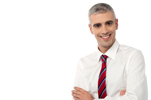 Handsome male executive with crossed arms over white