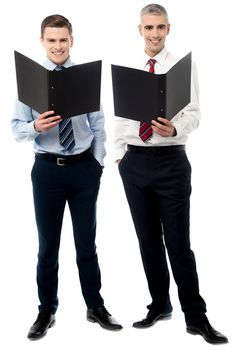 Young male executive posing with file folder