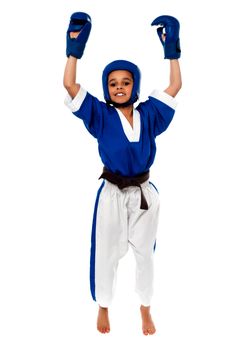 Successful karate kid with raised arms