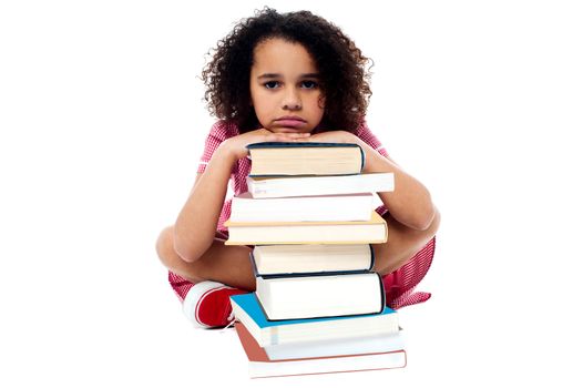 Tired schoolgirl resting her arms on books