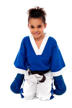 Happy karate girl sitting on floor after practice