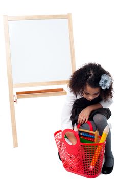 Little girl taking something from her basket bag