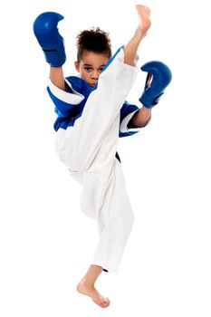 Little karate kid kicking by a leg
