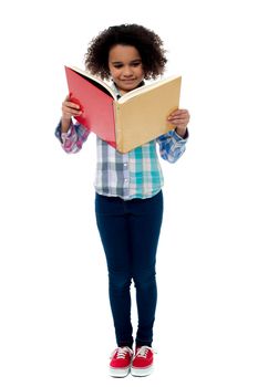 Full length image of school girl reading a book 