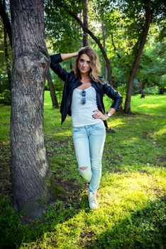 Hipster beautiful girl in leather jacket and jeans. Fashion girl posing with leather jacket