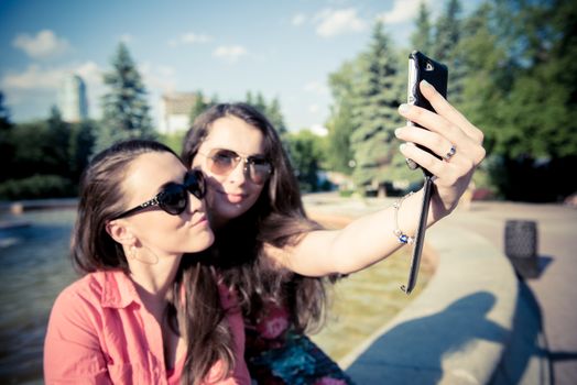 Two young women taking a selfie outdoors in summer