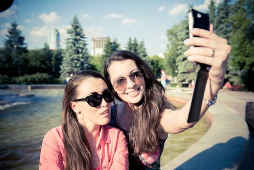 Two young women taking a selfie outdoors in summer