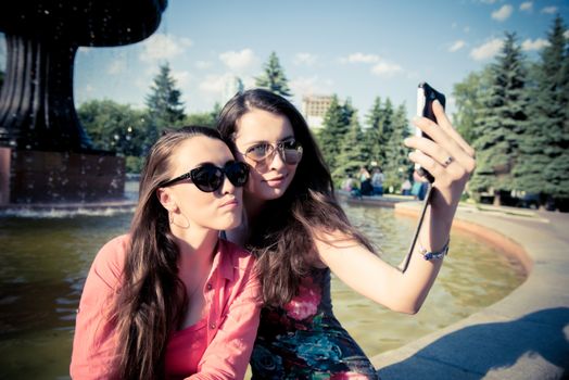 Two young women taking a selfie outdoors in summer