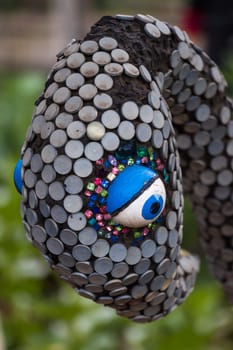 An abstract sculpture of a birds head covered in colorful sequins.