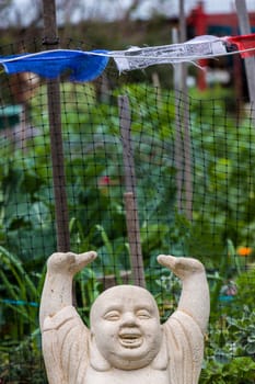 A statue of a Buddha with his arms over his head in joy.