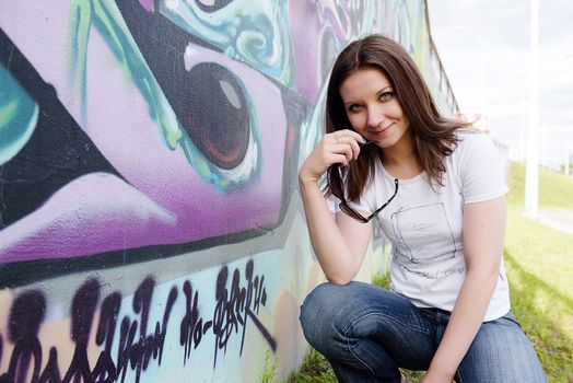 girl in sunglasses near graffiti wall