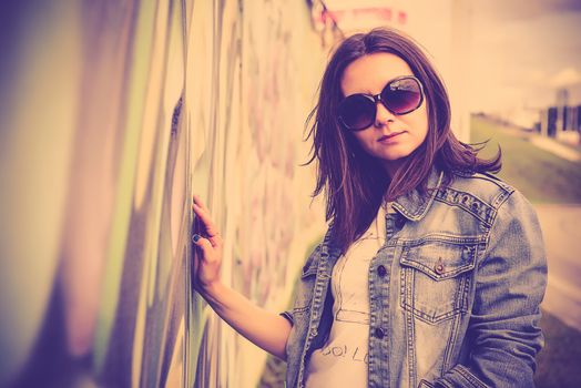 girl in sunglasses near graffiti wall