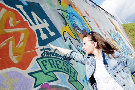 girl in sunglasses near graffiti wall