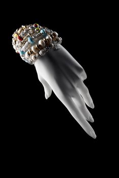 white hand mannequin with bracelets on a black background