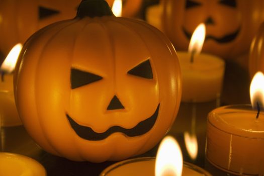 Small Halloween toy Pumpkins surrounded by orange tealight candles