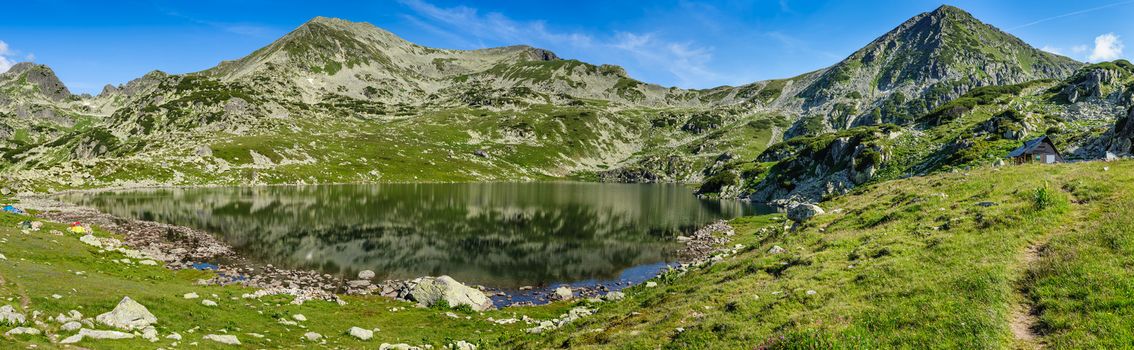 Extra high resolution detailed landscape panorama of Bucura lake in Retezat National Park mountains, South Carpatians, Transylvania, Romania, Europe. Small lake with blue sky reflection at center.