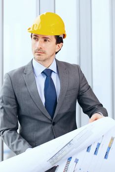 Architector in hardhat and business suit with construction plans