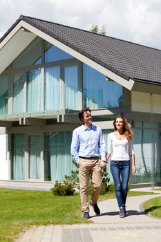 couple walking from house while holding hands