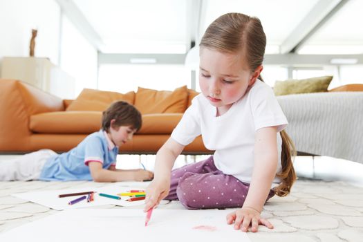 brother and sister drawing pictures with coloring pencils