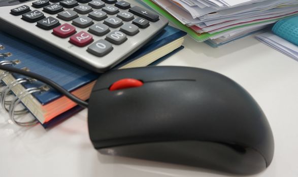 Office equipment such as documents, files, calculator, notepad and computer mouse placed on desk.  
                         