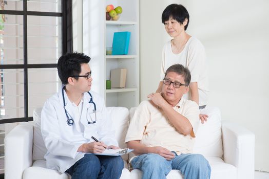 Doctor and patient. Asian old people consult family doctor, sitting on sofa. Senior retiree indoors living lifestyle.