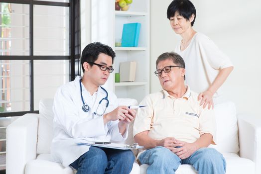 Doctor and patient healthcare concept. Asian elder man consult family doctor, sitting on sofa. Senior retiree indoors living lifestyle.