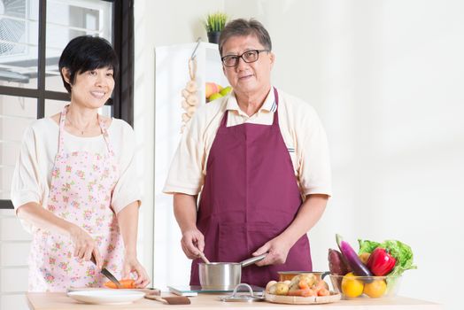 Asian senior couple preparing food at kitchen. Seniors living lifestyle at home.