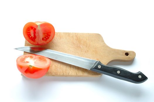 Tomatoes and knife on chopping board on white background