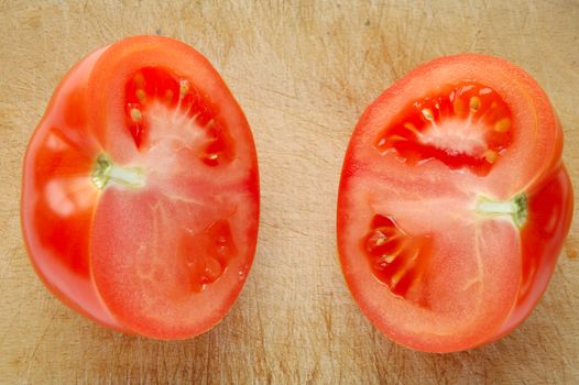 Tomato on brown wooden chopping board