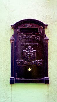 antique postal black metal box on pastel green wall in Burano, Venicce, Italy