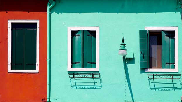 red and green wall with windows house building in Burano, Venice, italy