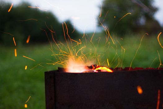 barbecue sparks fly from the barbecue evening dinner cooking coals of fire