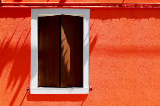 Window house in Burano on orange color wall building architecture, Venice, Italy
