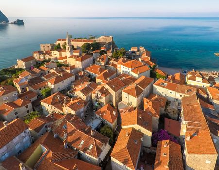 View of old town Budva from the top: Ancient walls and tiled roof of old town Budva, Montenegro, Europe. Aerial shoot
