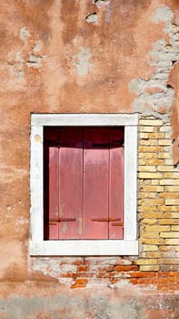 red wood window and ancient decay wall building architecture in Murano, Venice, Italy