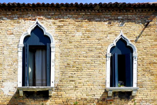 two windows and ancient brick wall building architecture in Murano, Venice, Italy