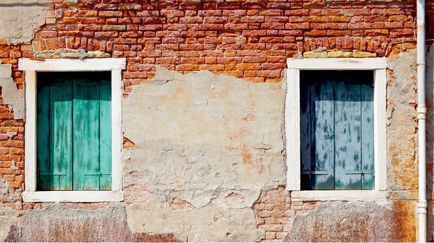 two windows and ancient decay brick wall building architecture in Murano, Venice, Italy