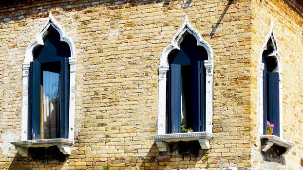 windows at coroner of house building architecture in Murano, Venice, Italy