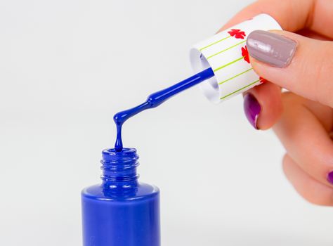 Blue nail polish drop on white background