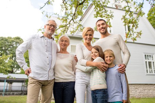 family, happiness, generation, home and people concept - happy family standing in front of house outdoors