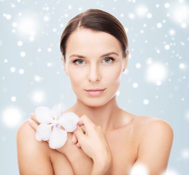 health and beauty concept - relaxed woman with orhid flower
