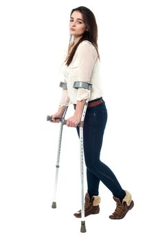 Full length image of teen walking with crutches