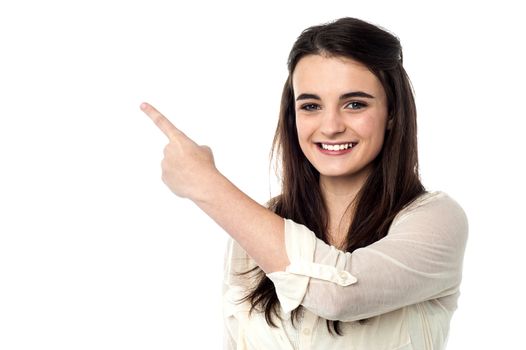 Pretty girl pointing at copy space area 